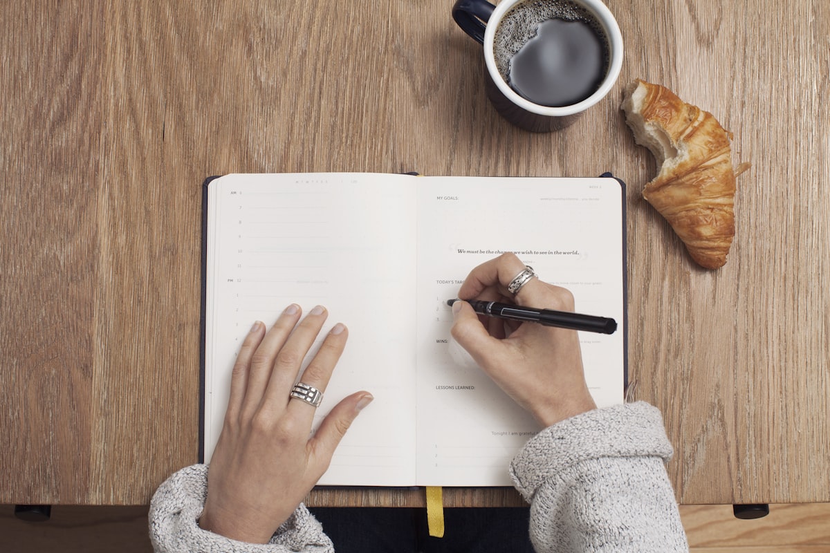 Person reading at a desk with coffee and morning light